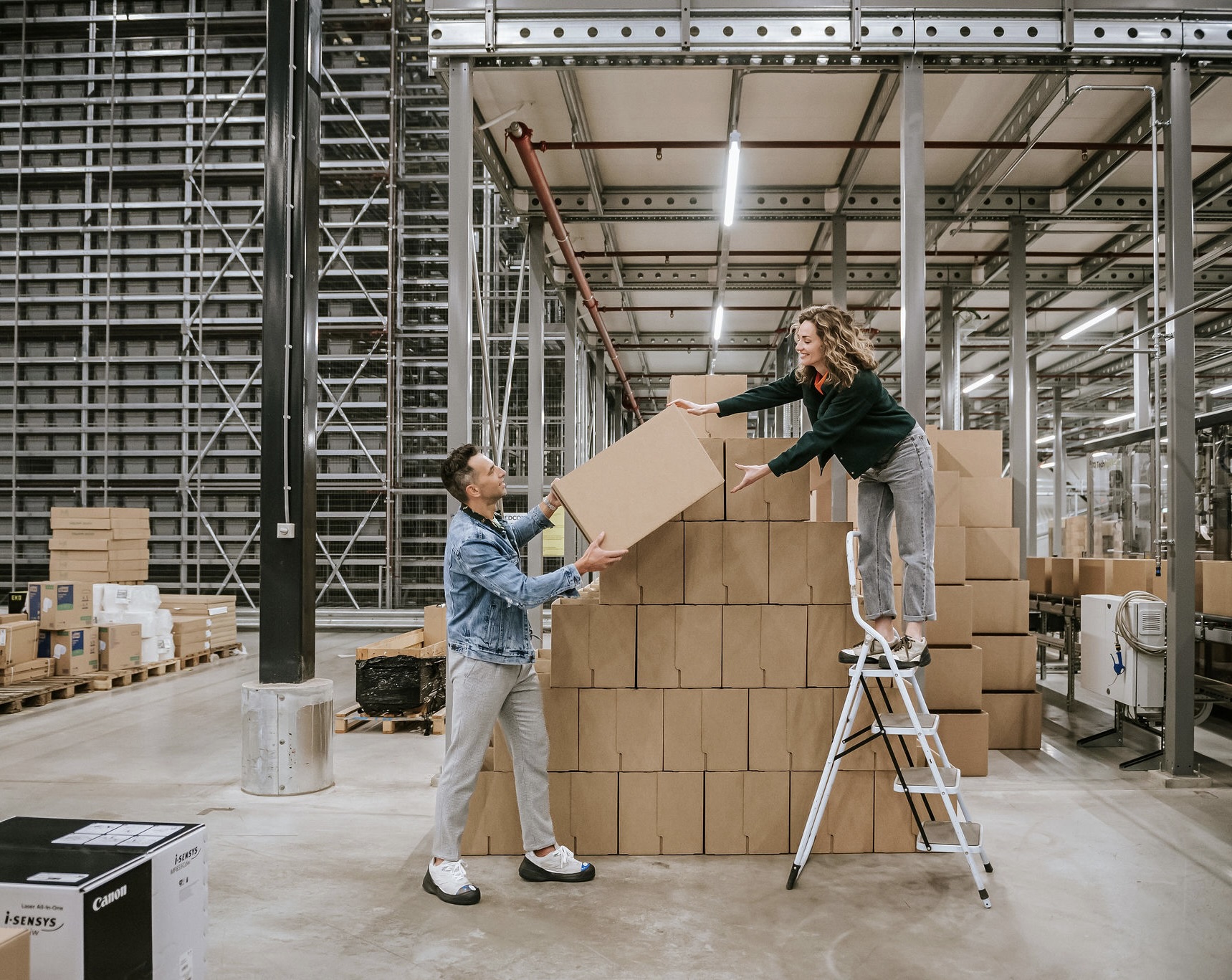 Jan en Heleen van Pack Company geven elkaar een kartonnen doos aan.